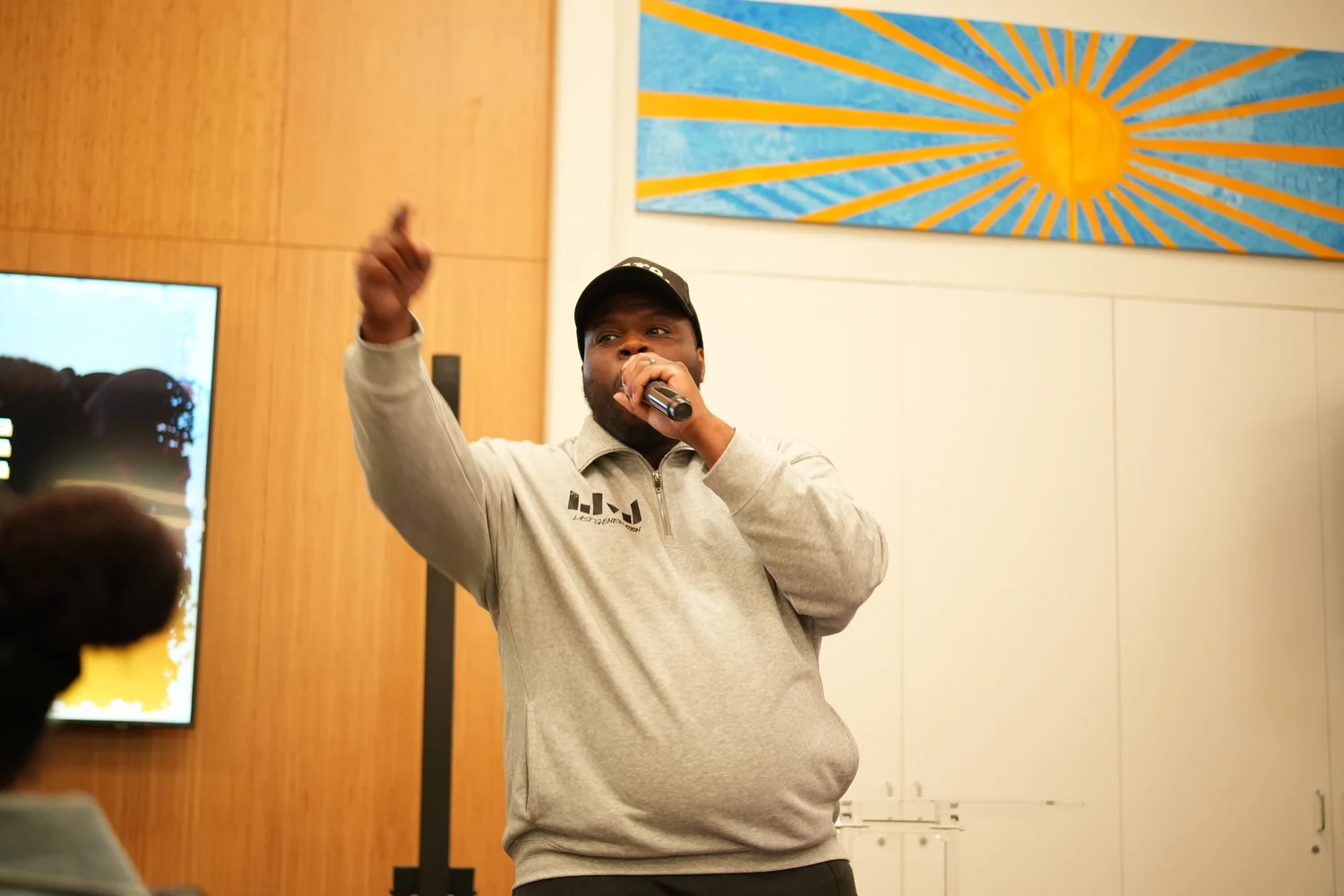 Performer pointing upward while holding a microphone.