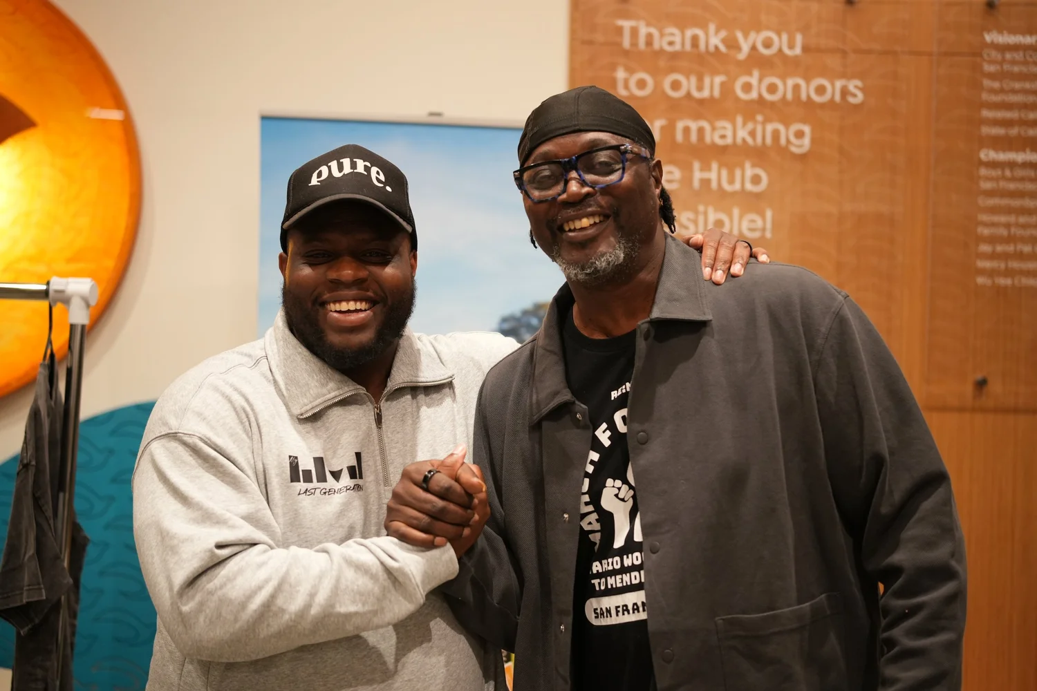 Two smiling participants clasping hands for a photo.