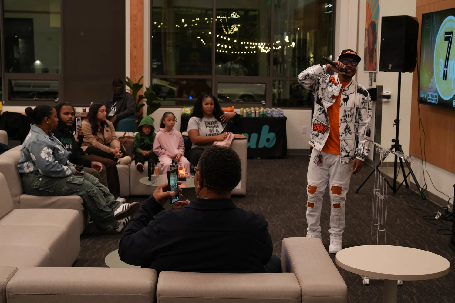 Performer addressing a closely seated audience.