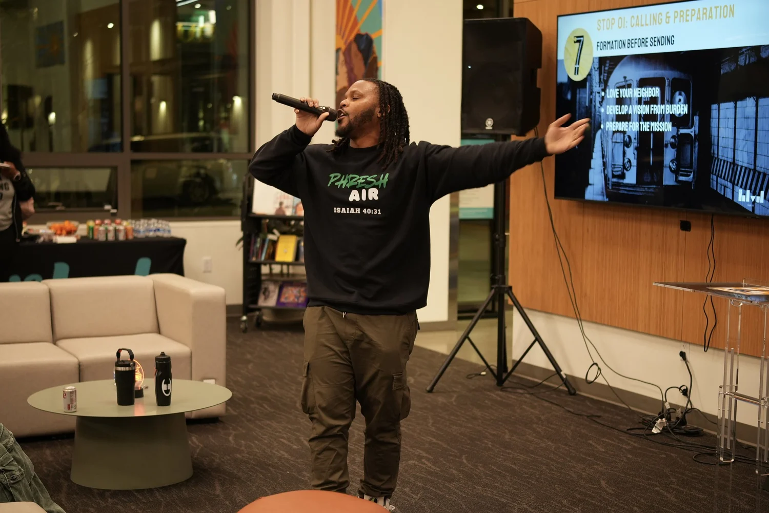 Performer with long hair spreading both arms.