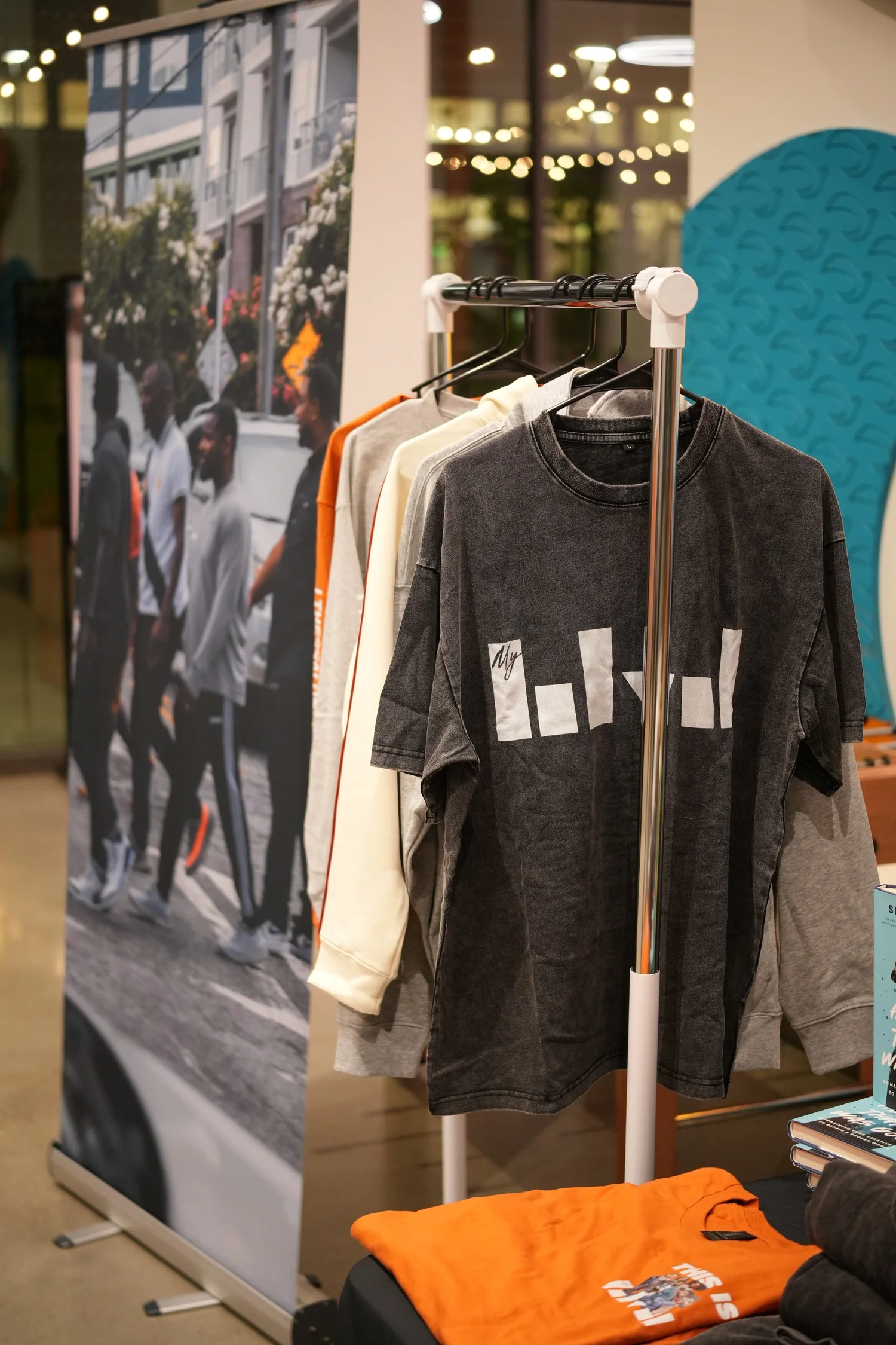 Shirts hanging on a merchandise rack beside a display table.