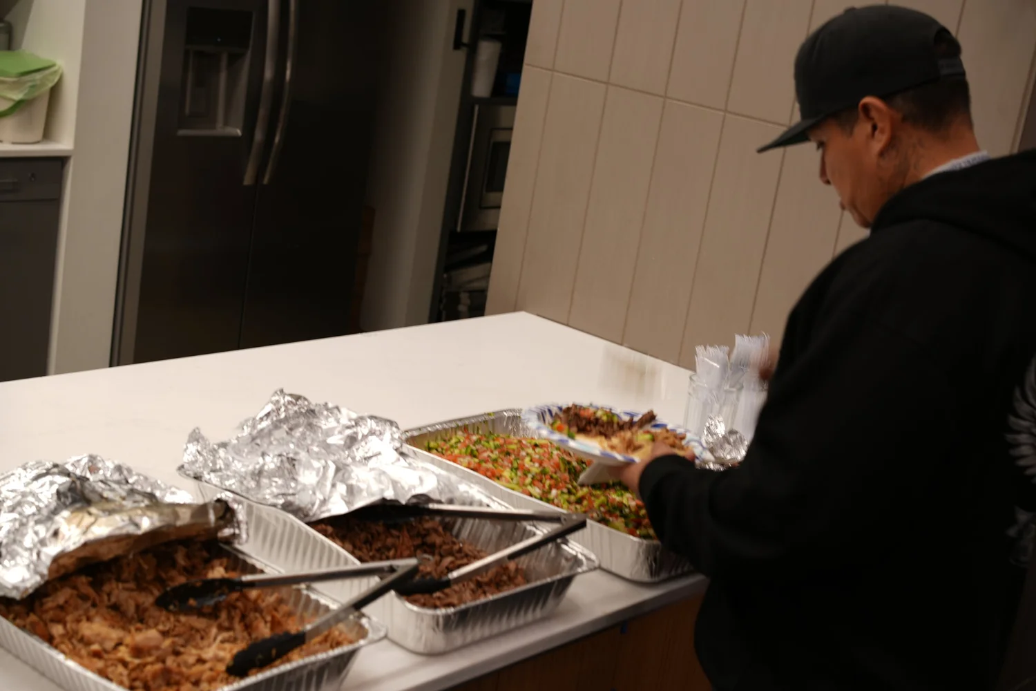 Guest serving food from foil trays.