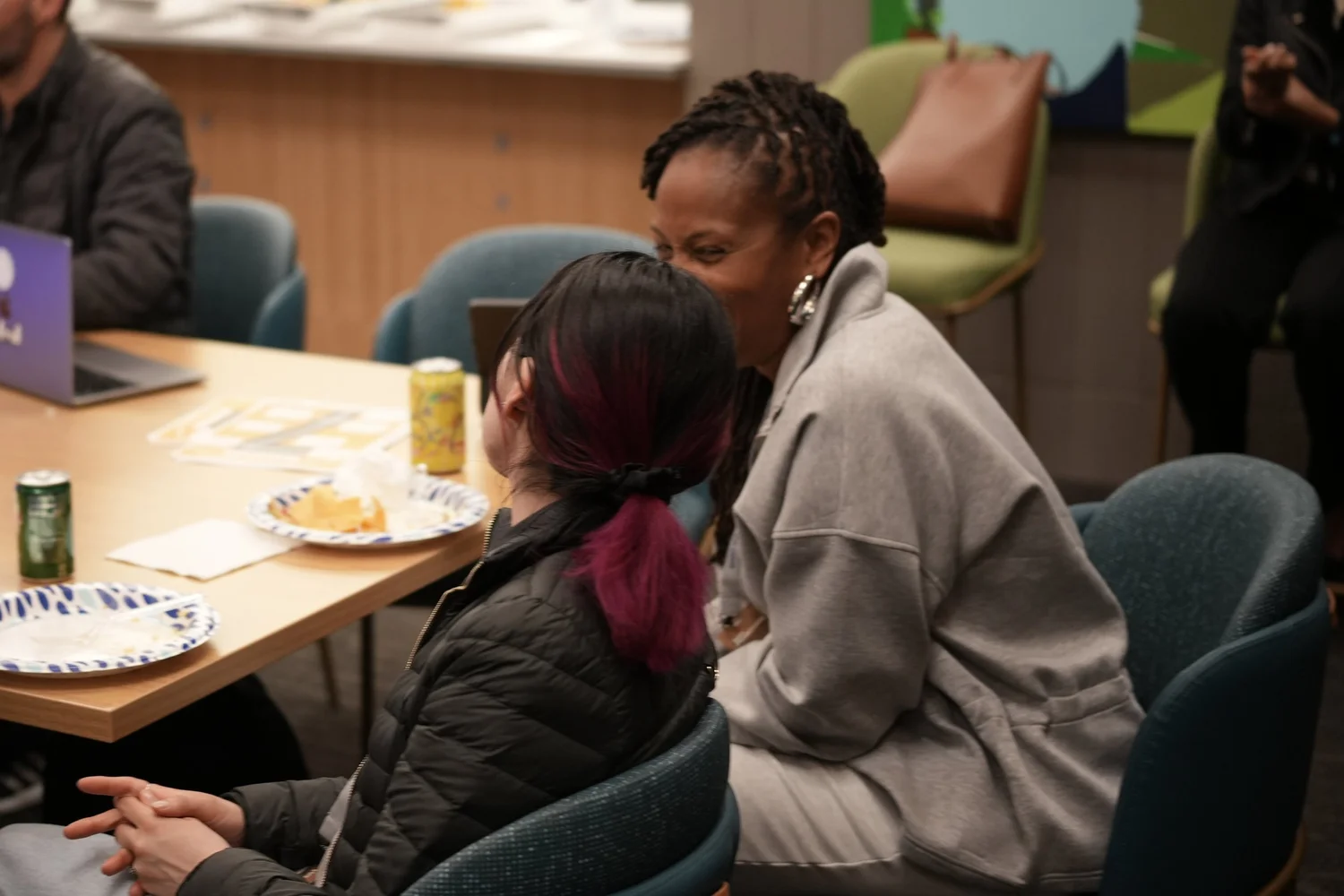Two attendees leaning together at a table.