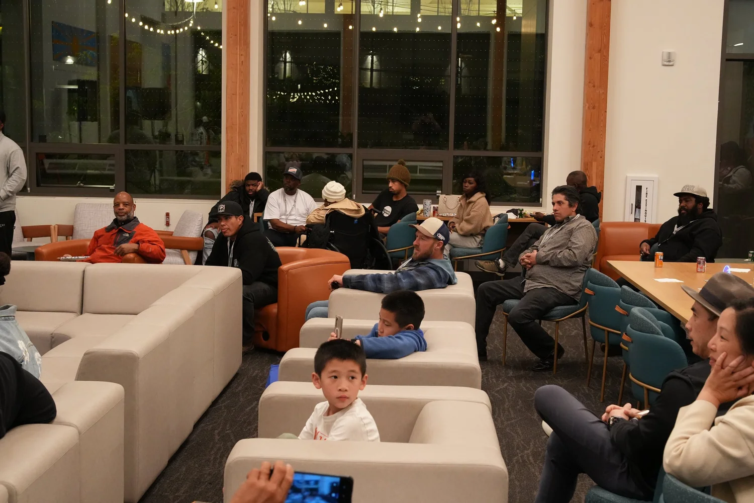Families seated on sofas and at tables during the gathering.