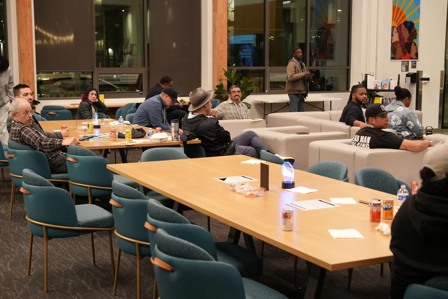 Wide view of guests seated around tables and sofas.