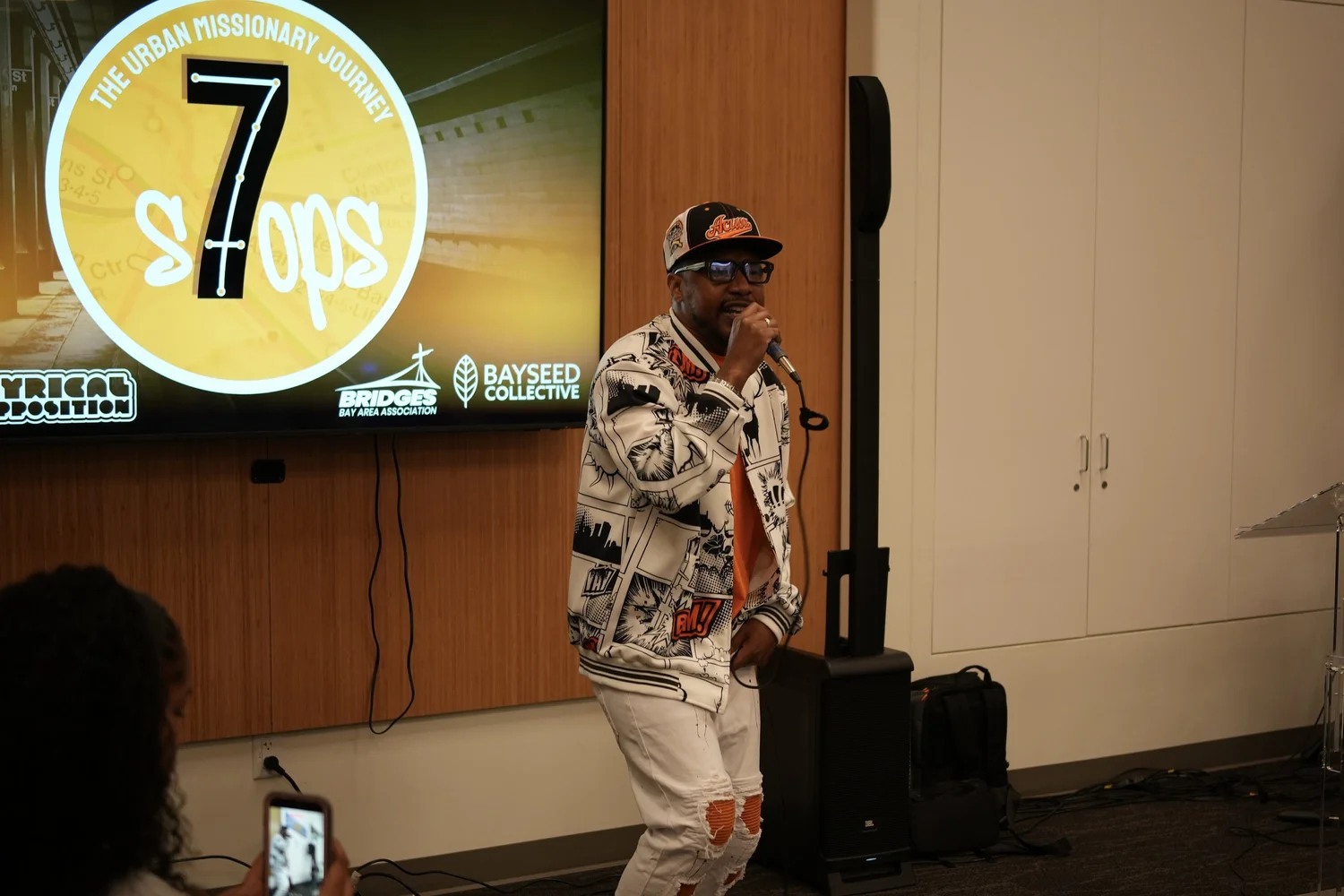 Close view of a performer beside the Seven Stops screen.