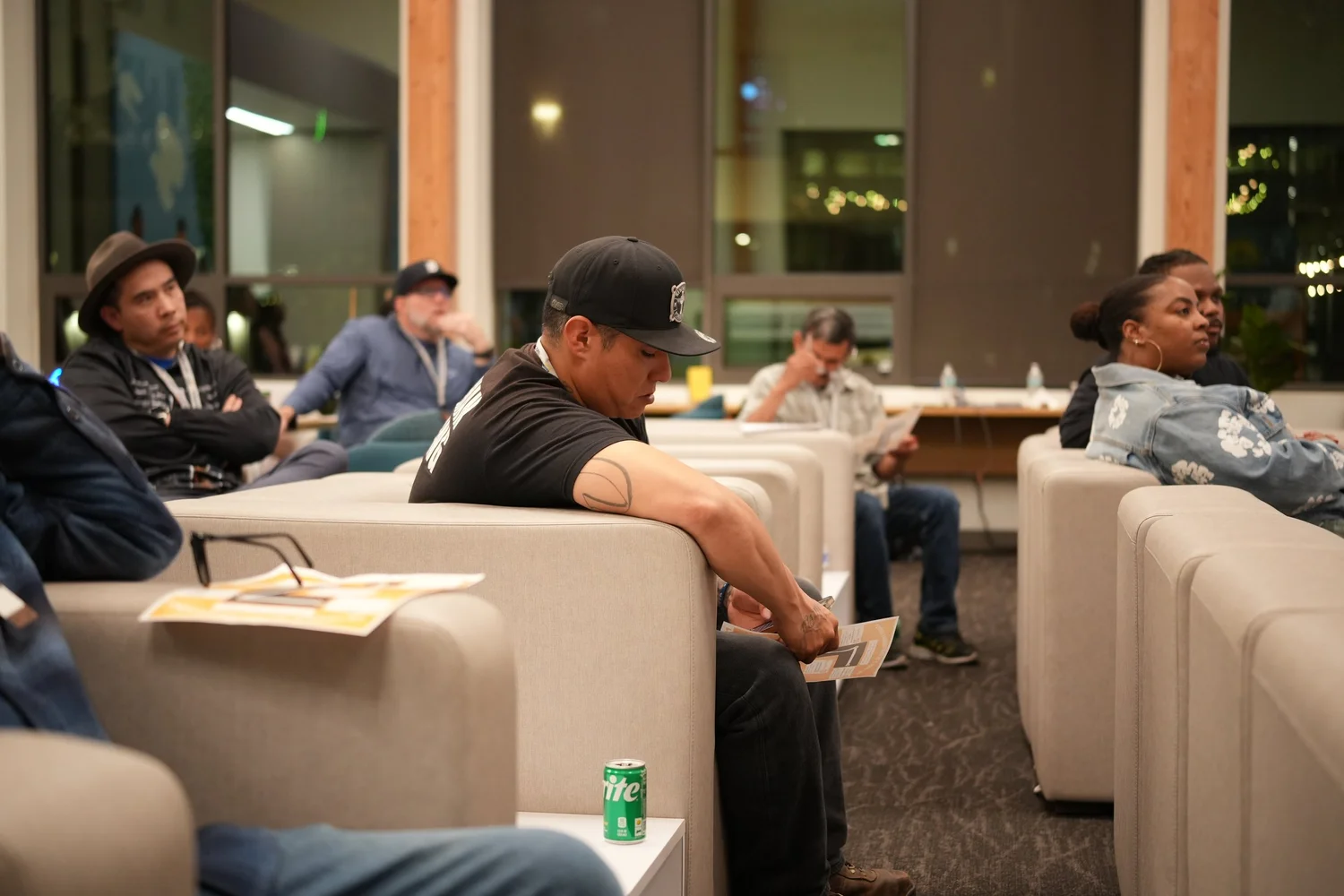 Attendees watching from light-colored sofas.
