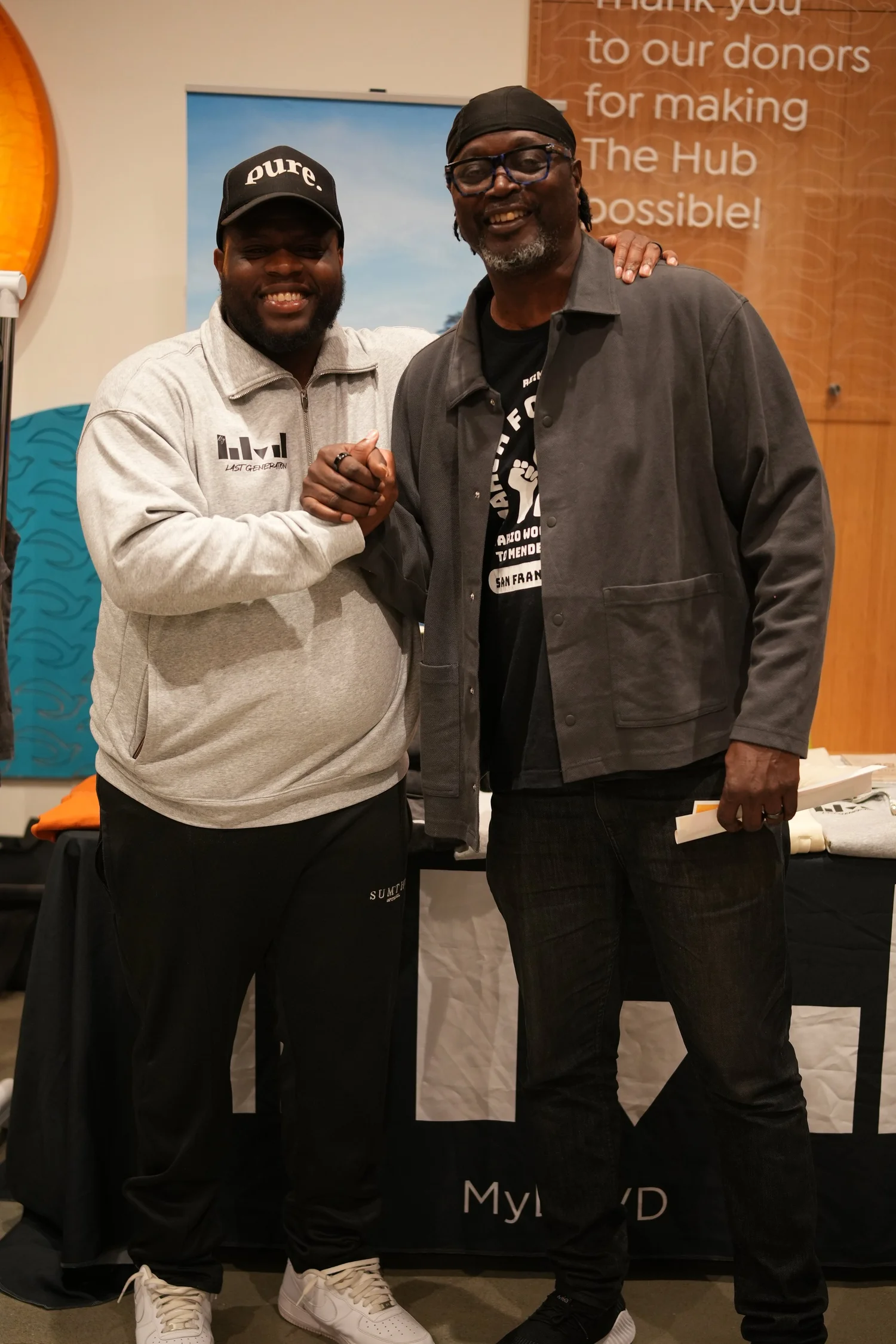 Two smiling attendees posing with clasped hands.