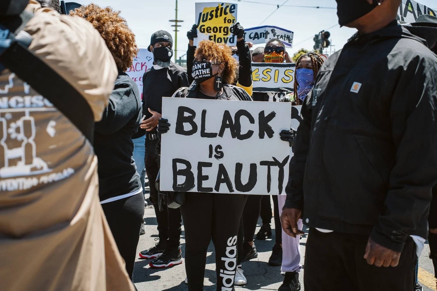 Participant holding a sign reading Black Is Beauty.