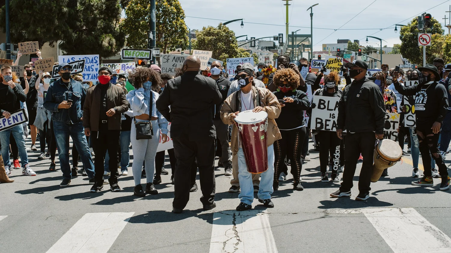 Crowd assembled across the street with signs.