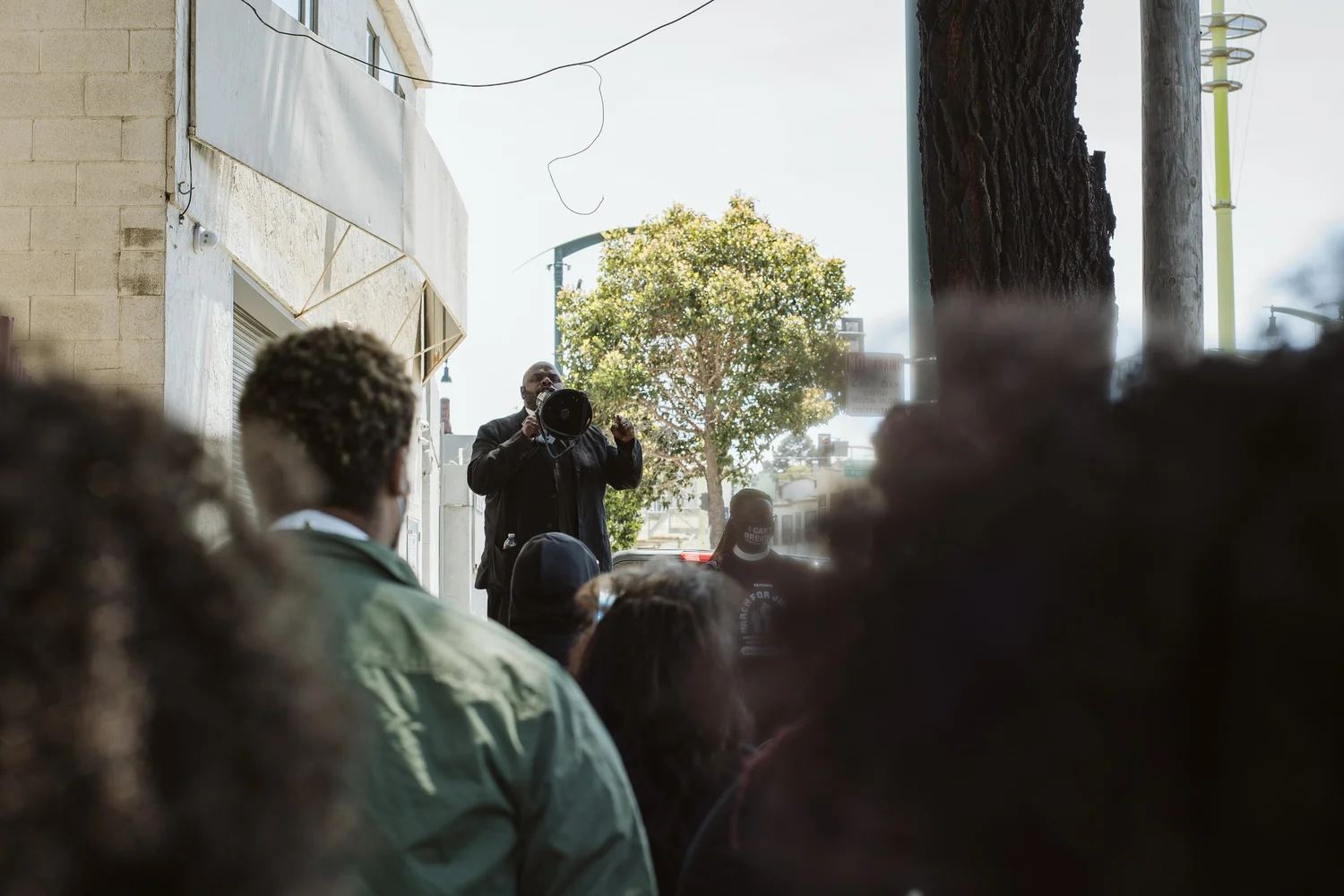 Crowd watching a speaker outside a building.