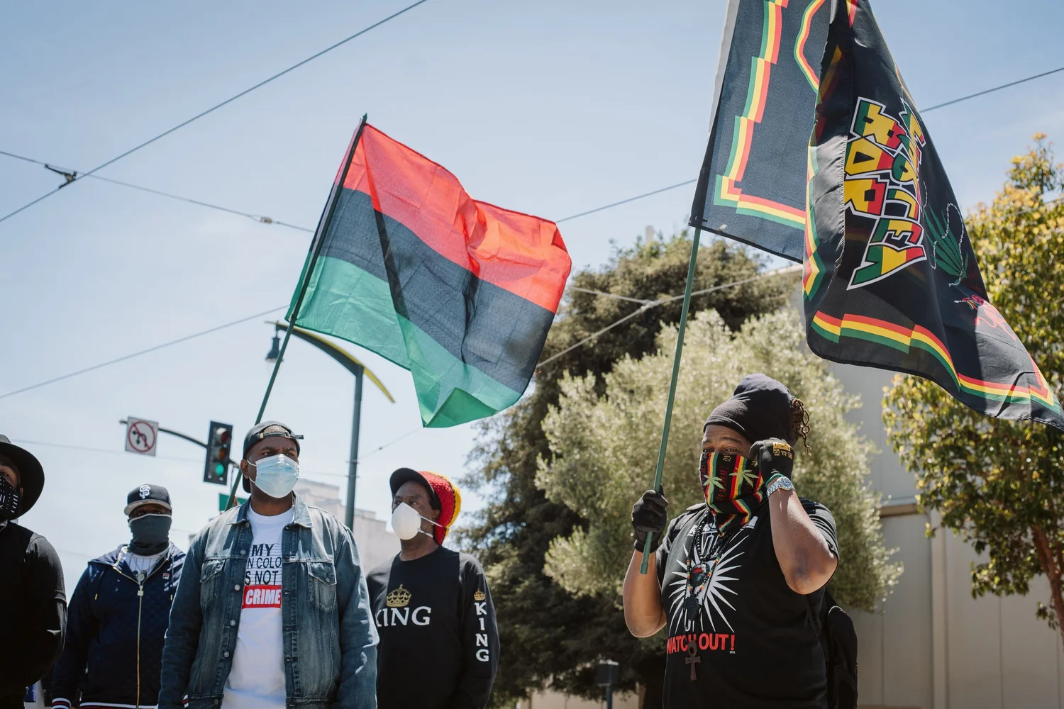 Participants beneath large flags, with one person holding a camera.