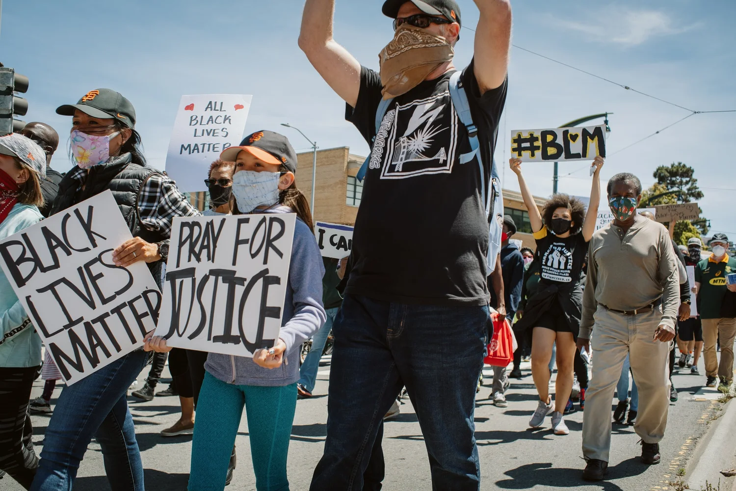 Marchers holding Black Lives Matter and Pray for Justice signs.