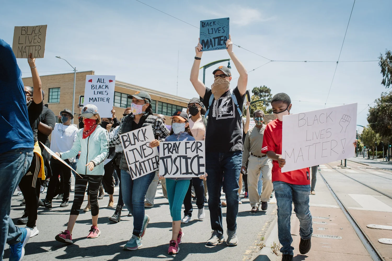 Marchers raising signs, including Black Lives Matter and Pray for Justice.