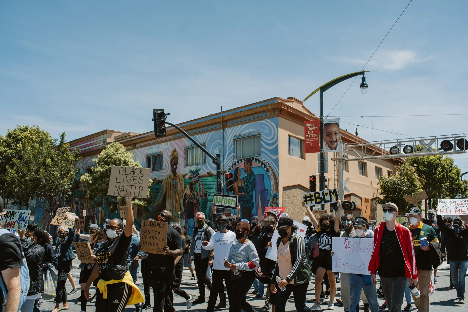 Wide view of marchers passing beneath transit wires.