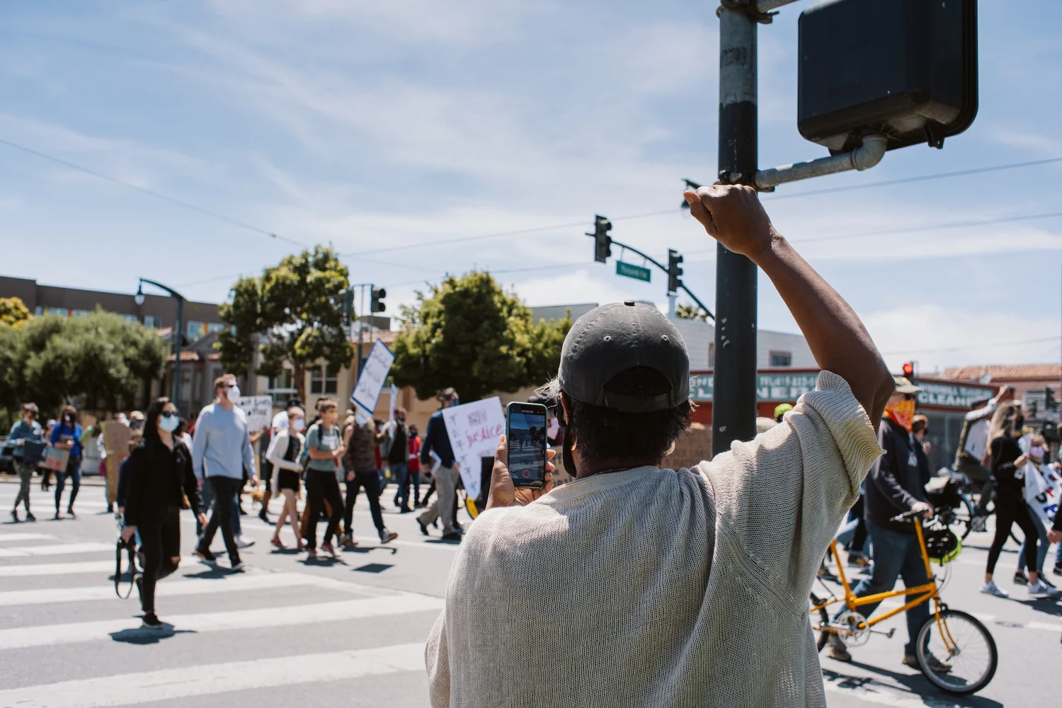 Participant holding up a fist beside a pedestrian signal.