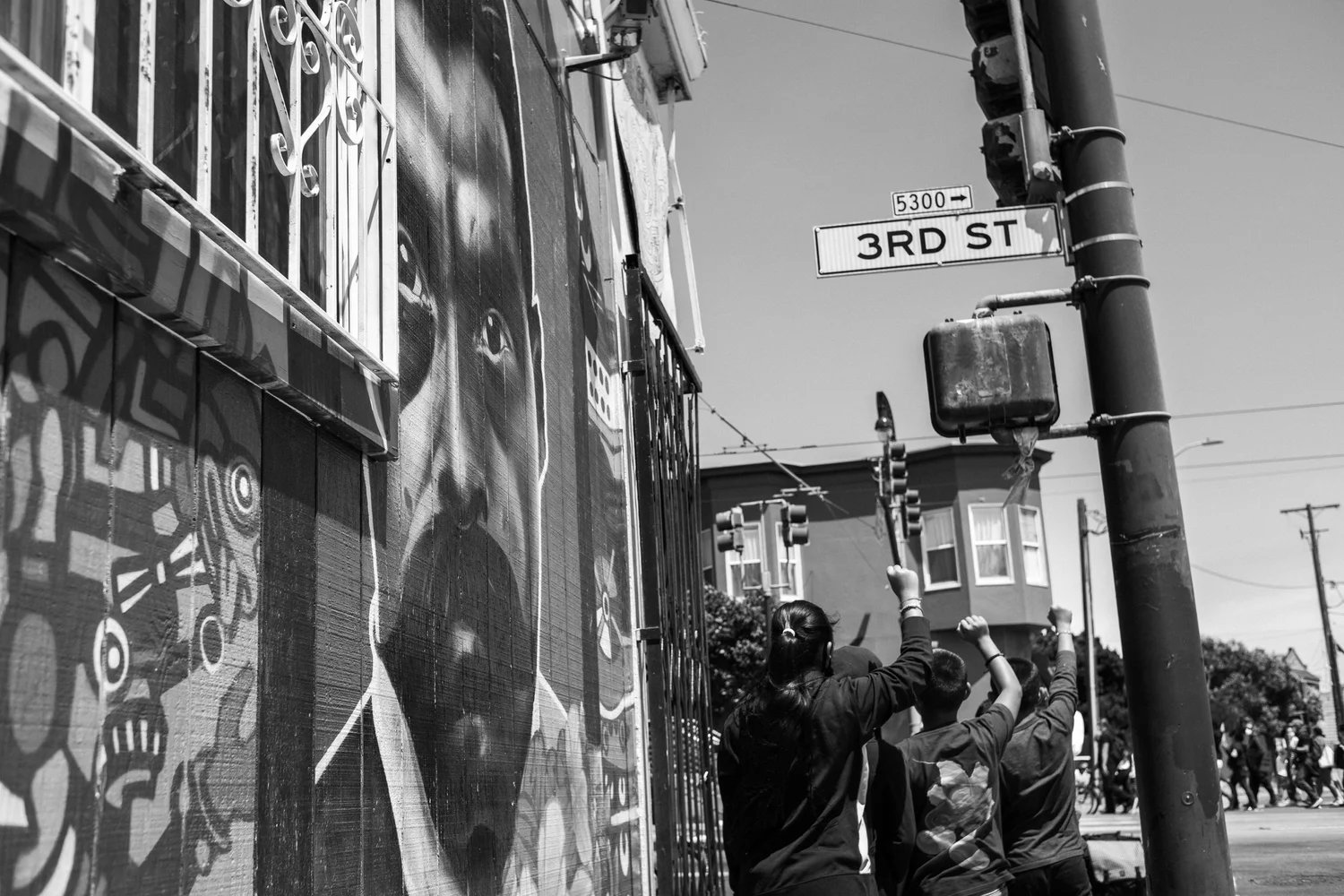 Black-and-white view of a Third Street corner and marching crowd.