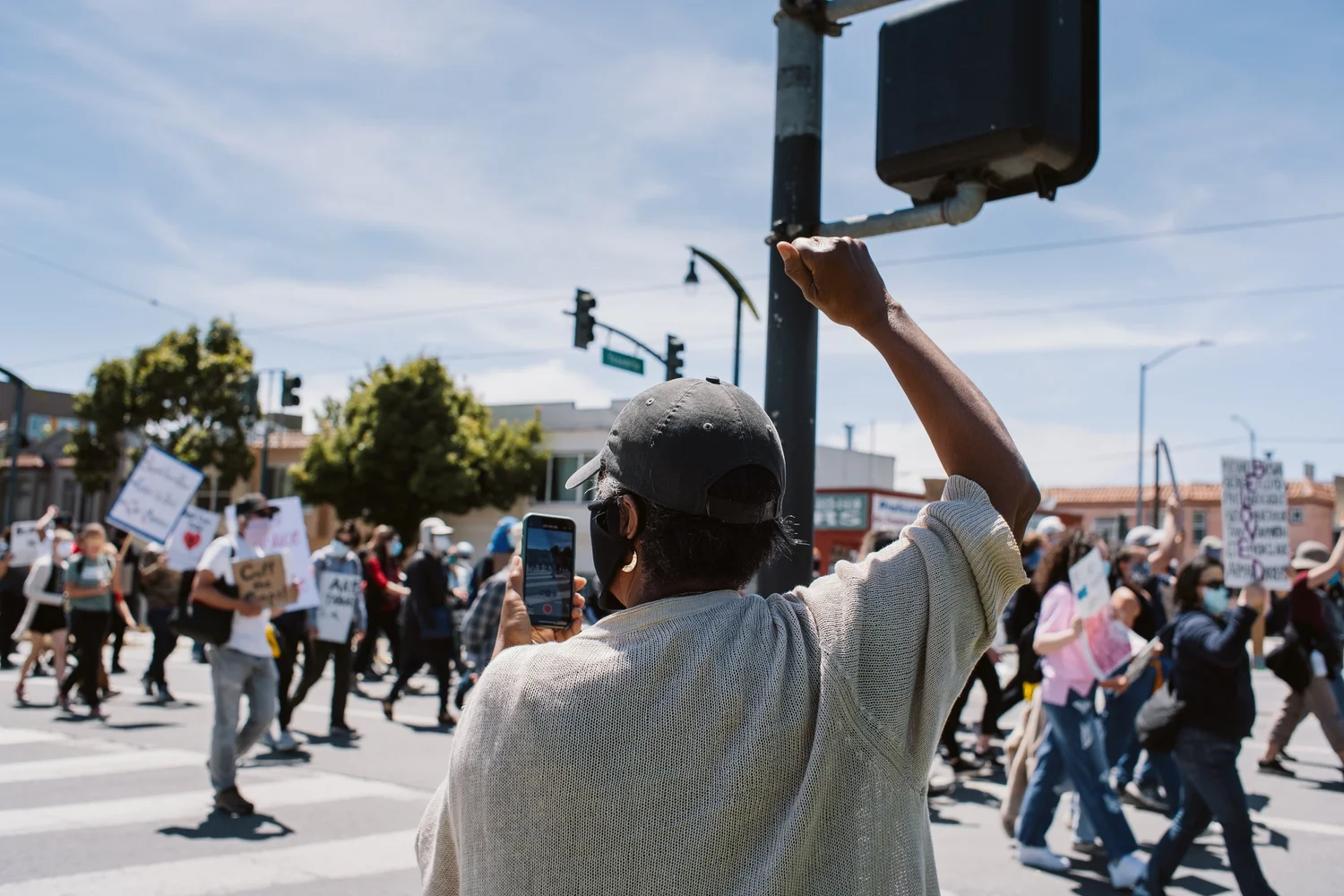 Bystander raising a fist as the procession crosses the intersection.