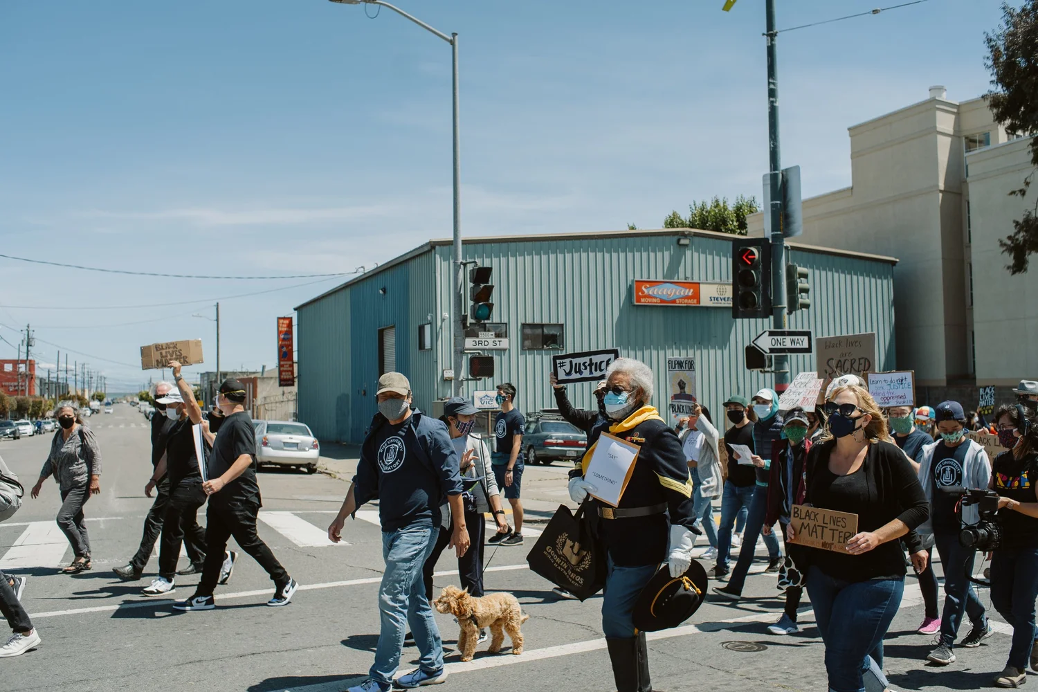 Marchers crossing a broad street.