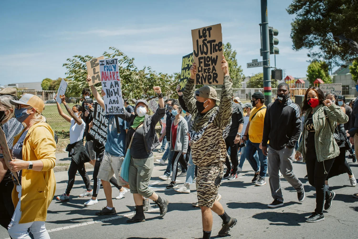 Participants walking with signs, including Let Justice Flow.