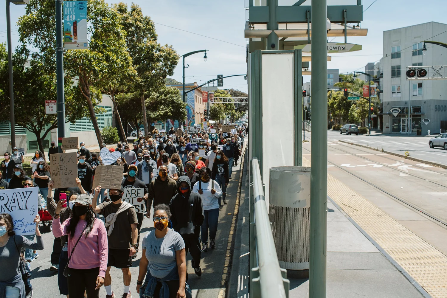 Marchers approaching along a transit platform.