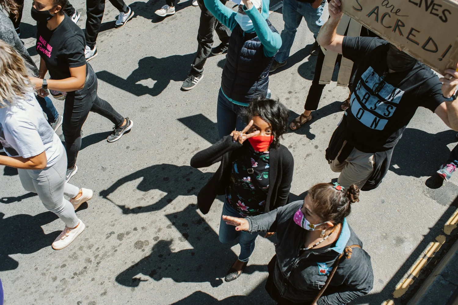 Overhead view of marchers holding hands and carrying signs.