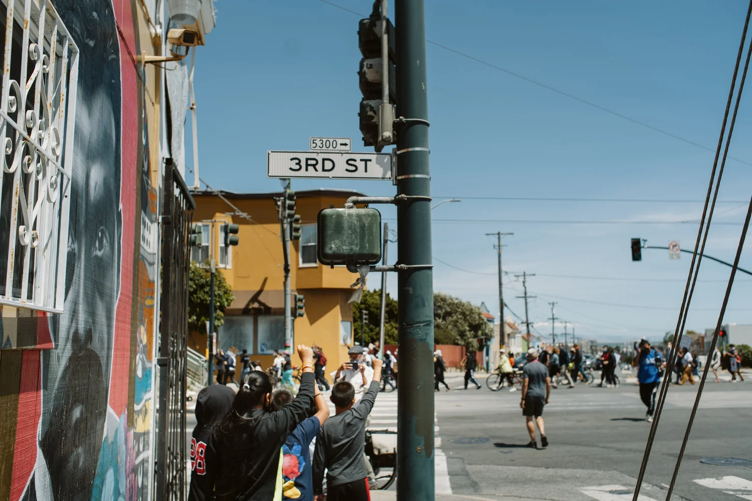 People watching the march beneath a Third Street sign.