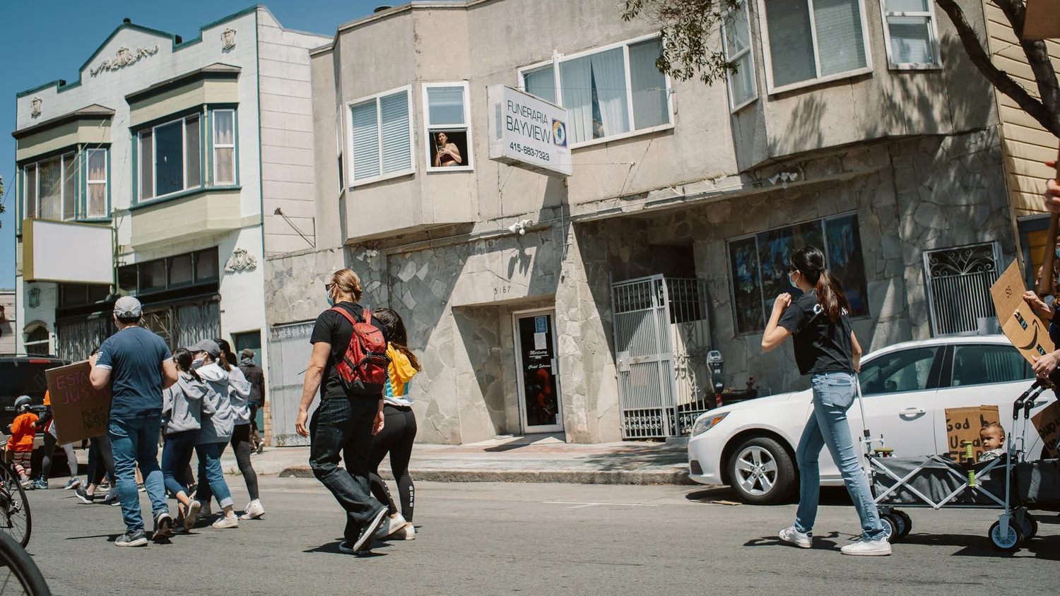 Marchers crossing in front of residential buildings.