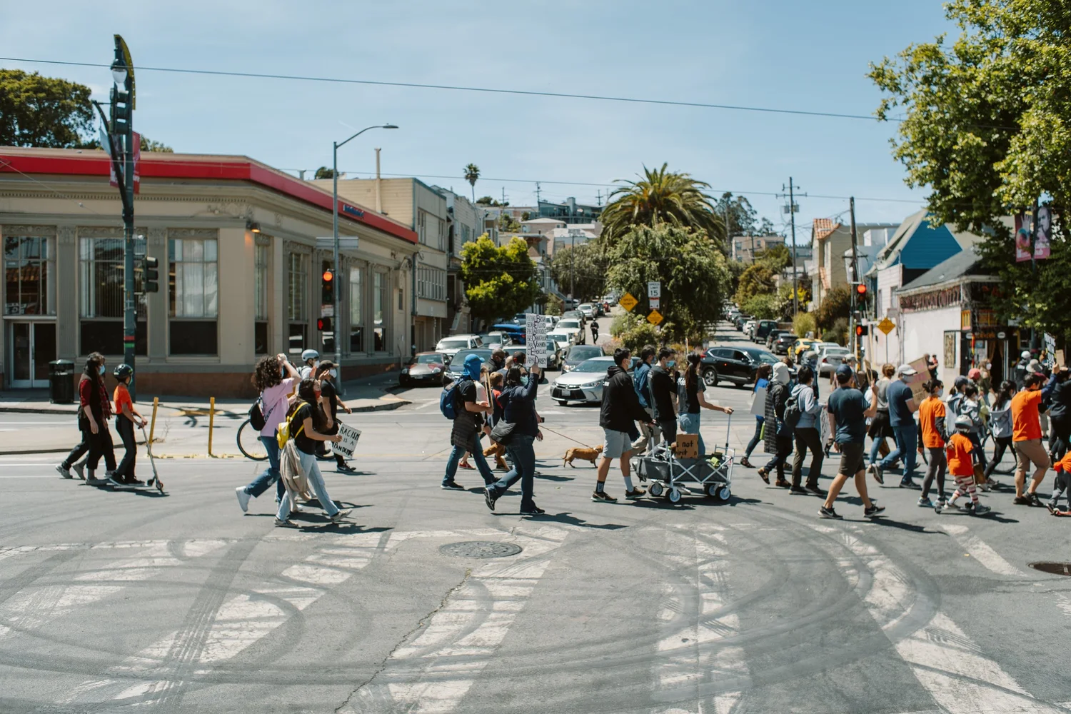 Wide view of the procession crossing an intersection.