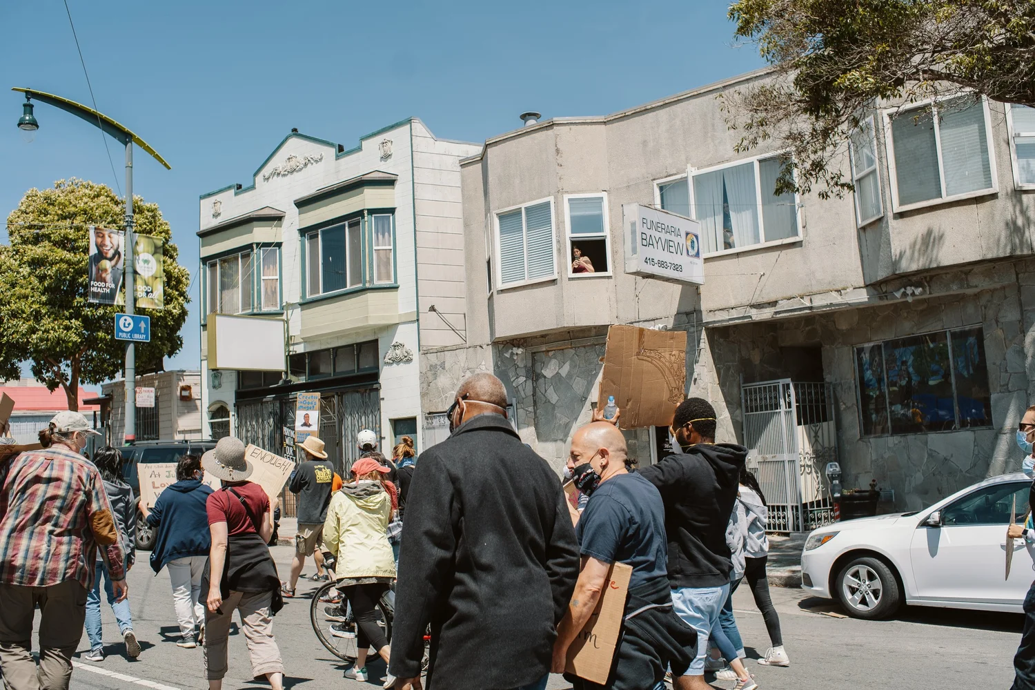 Participants walking along the street carrying cardboard signs.