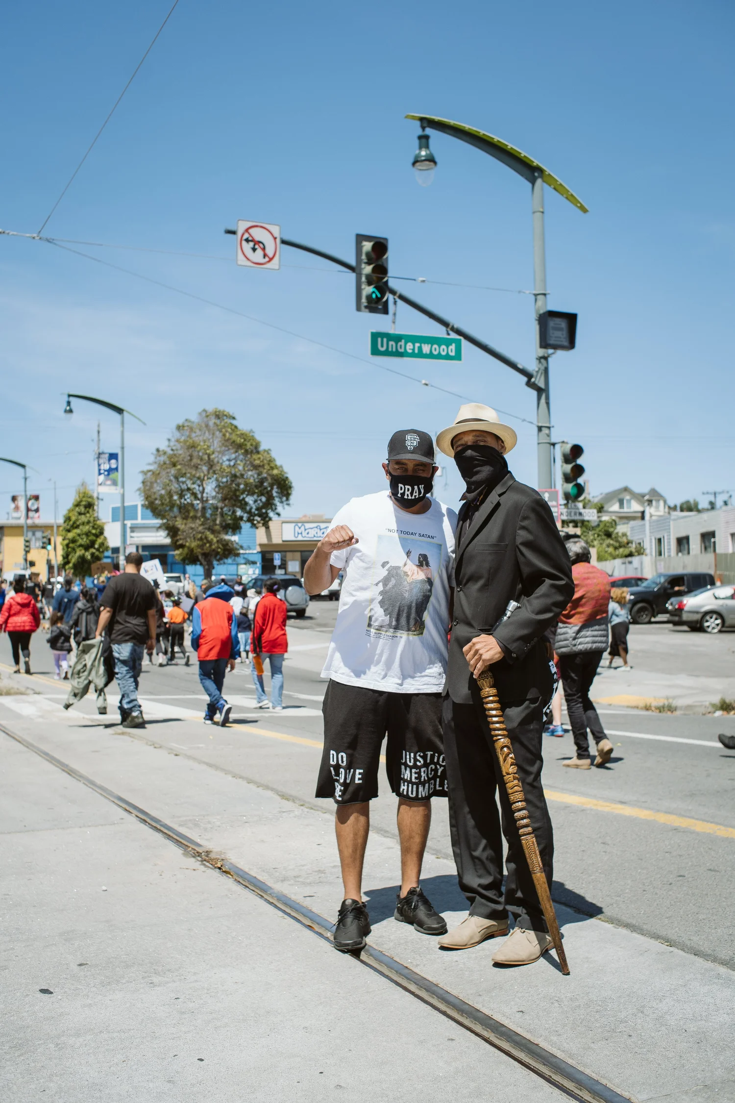 Two masked participants posing at a street crossing.