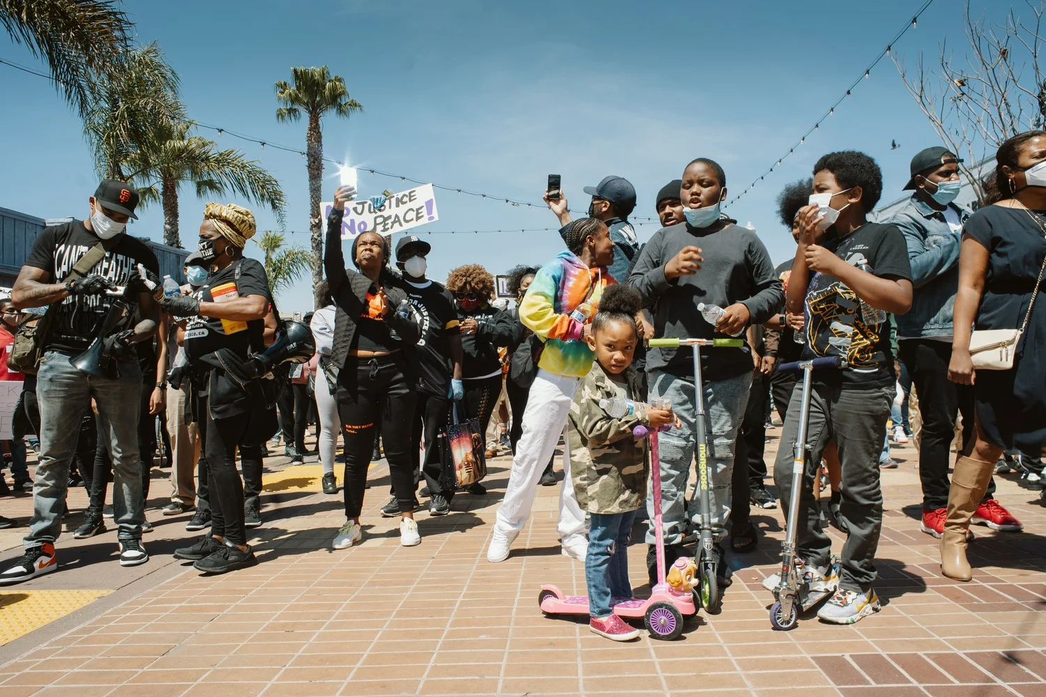 Families gathered with scooters near the front of the crowd.