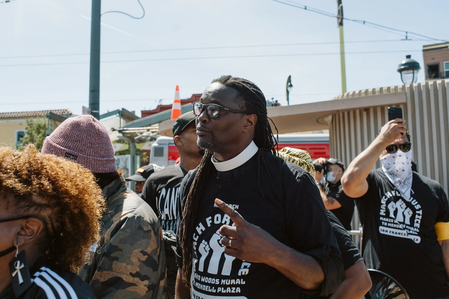 Participant wearing a clerical collar among the rally crowd.