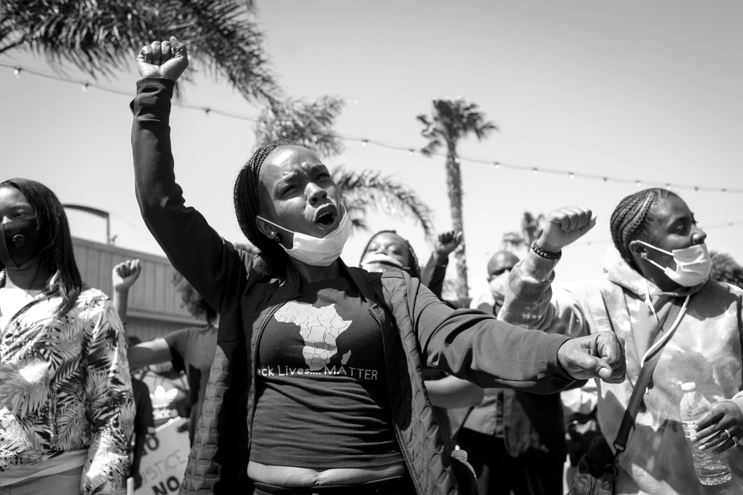 Black-and-white photo of participants raising their fists.