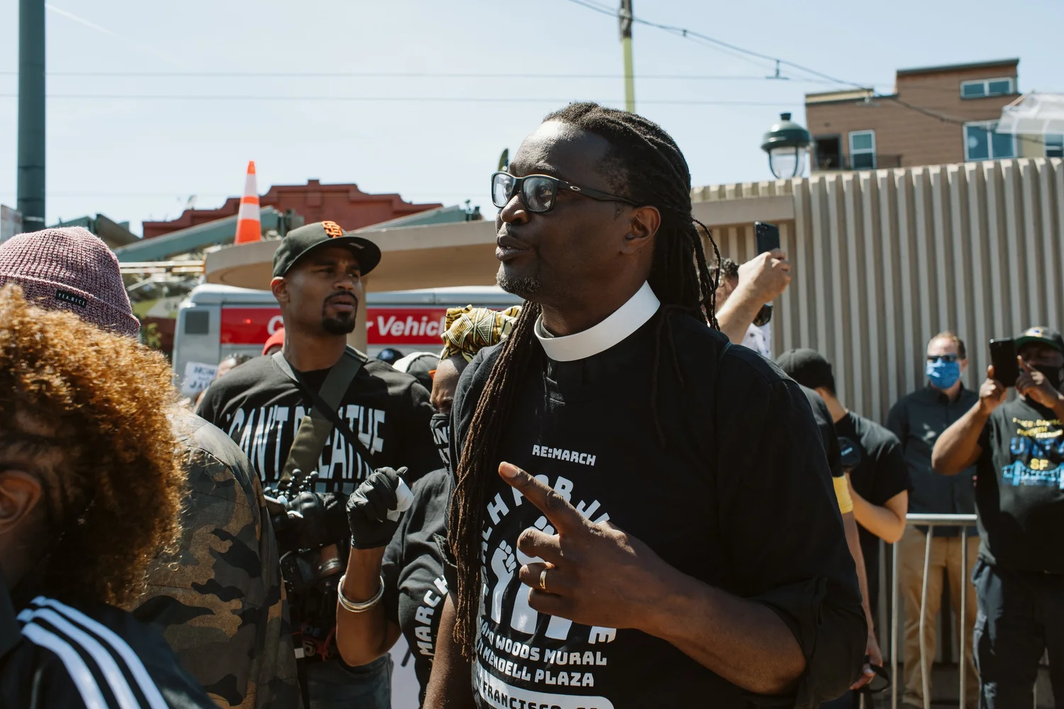 Close view of a participant with a clerical collar speaking among attendees.