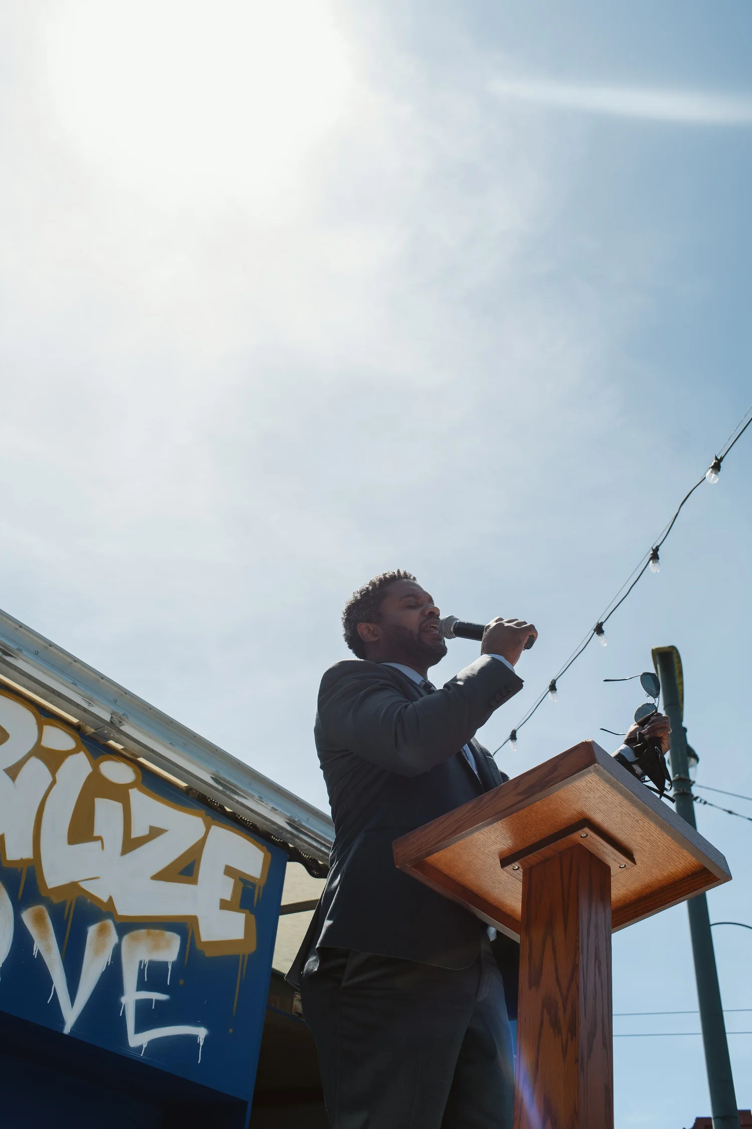 Low-angle view of a speaker holding a microphone at the lectern.