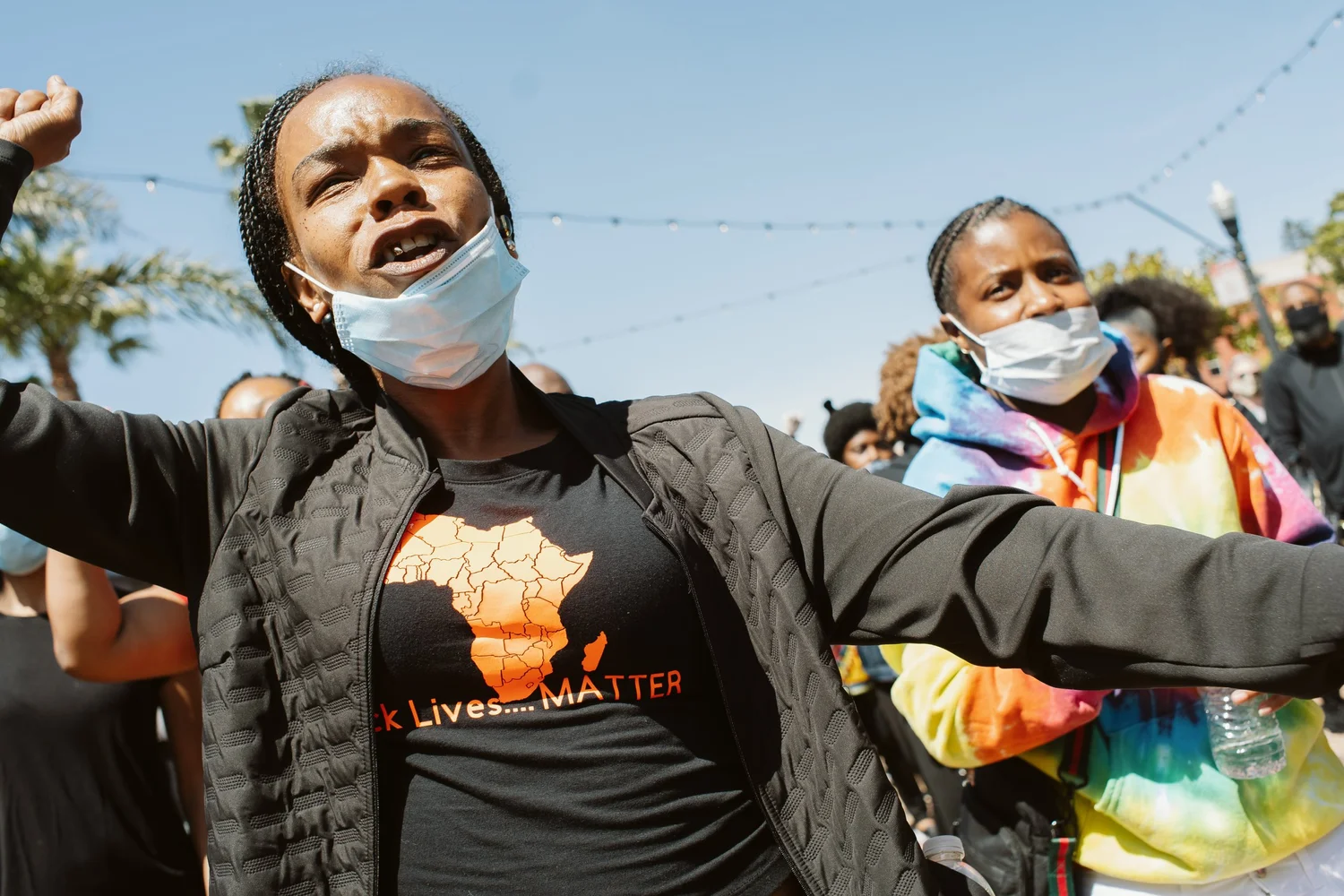 Participant extending both arms among people with raised fists.