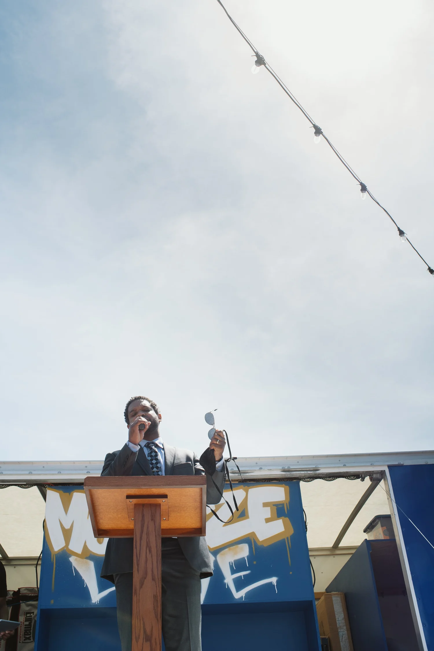 Speaker addressing the rally from a wooden lectern.