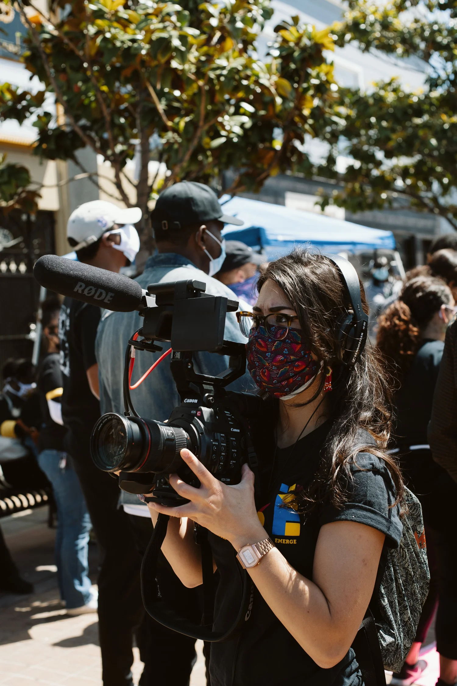 Camera operator filming the rally with a shoulder-mounted camera.