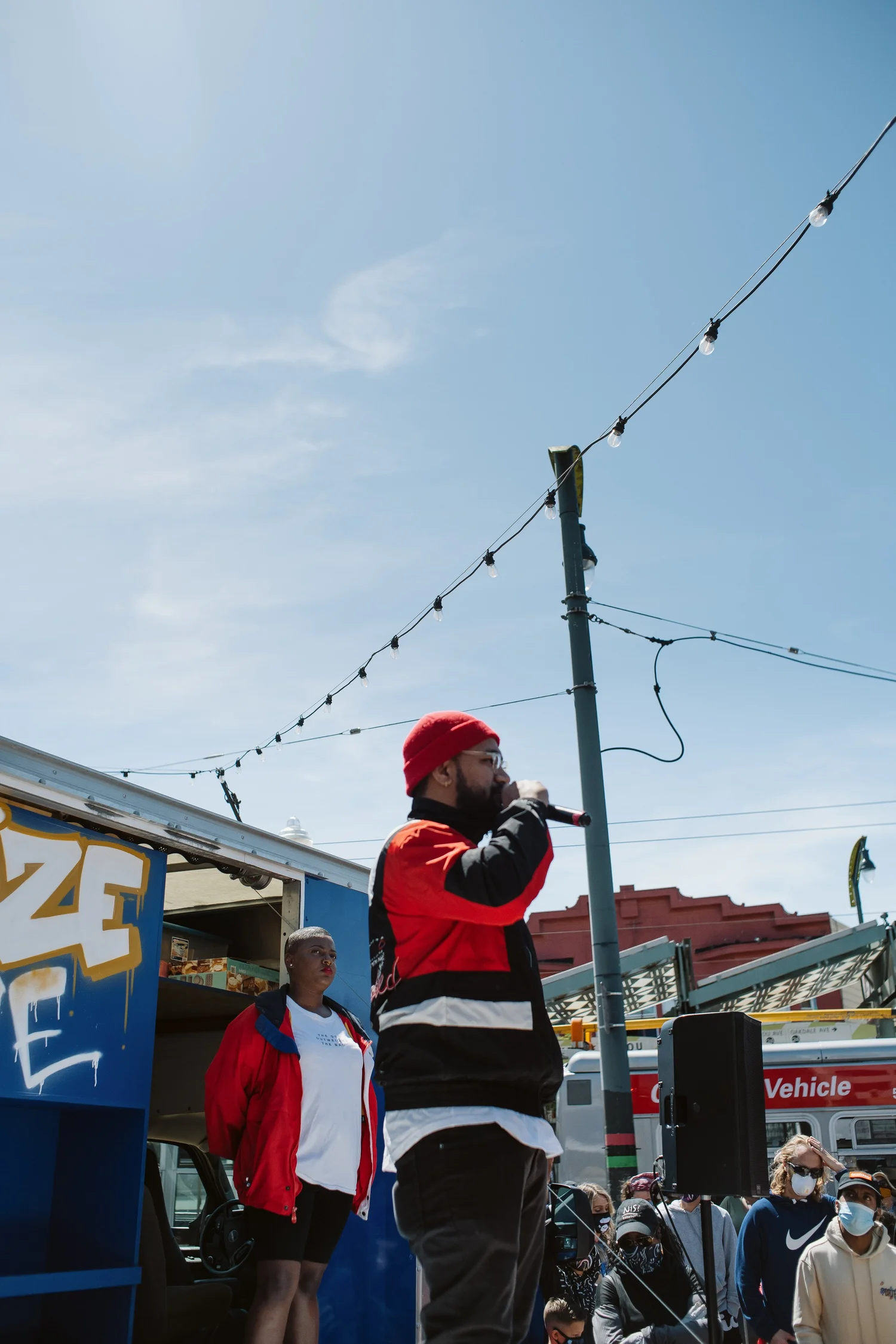 Vertical view of a performer wearing a red cap onstage.
