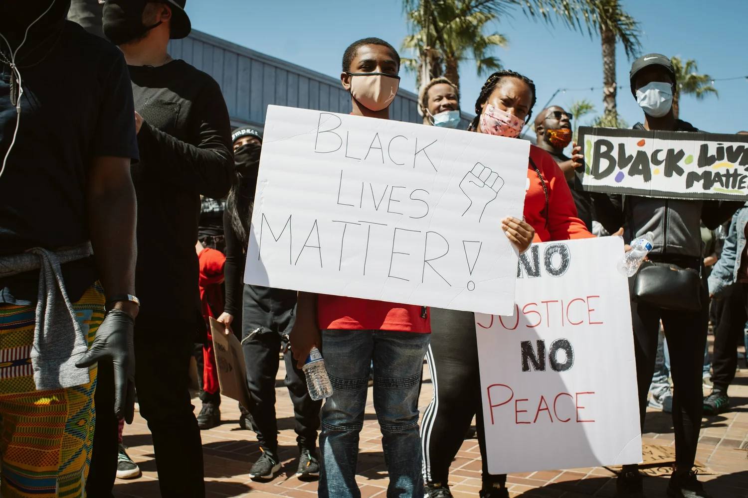 Participants holding Black Lives Matter and No Justice No Peace signs.