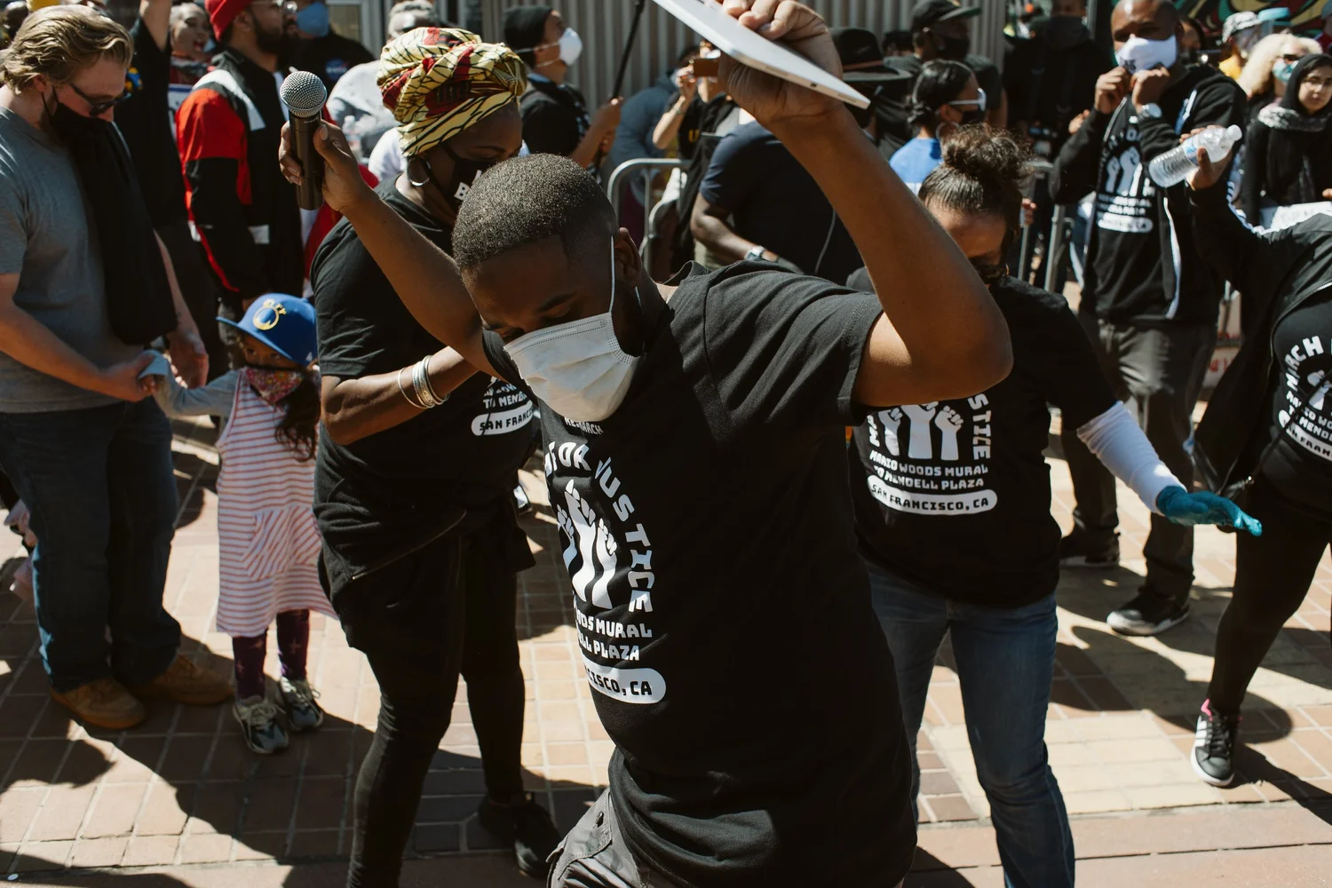 Participant holding arms aloft among the crowd.