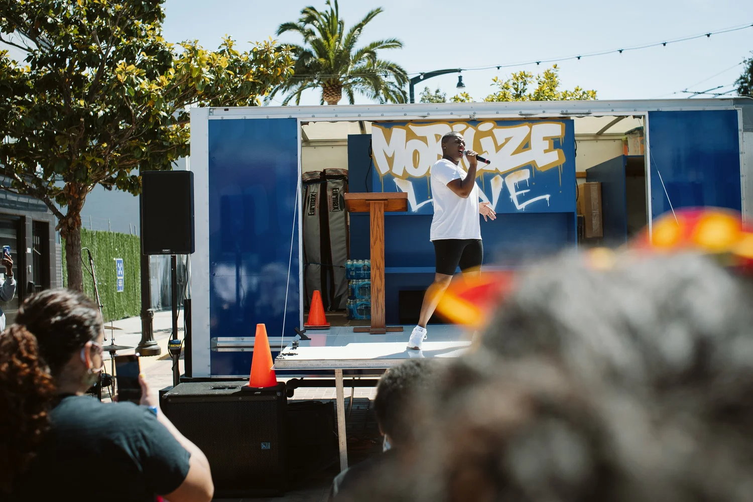 Audience watching the performer in front of the Mobilize Love lettering.