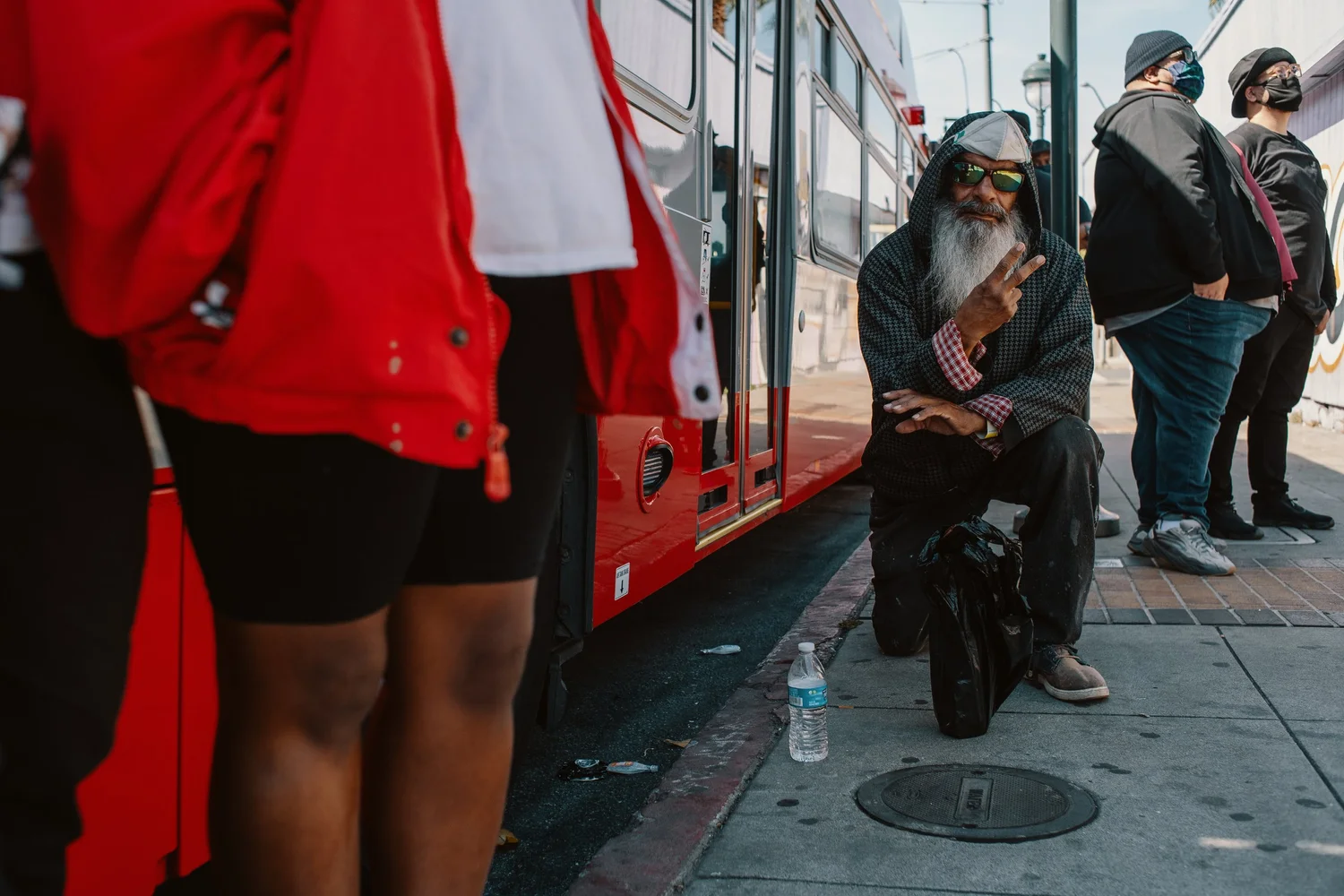 People standing beside a red transit vehicle.