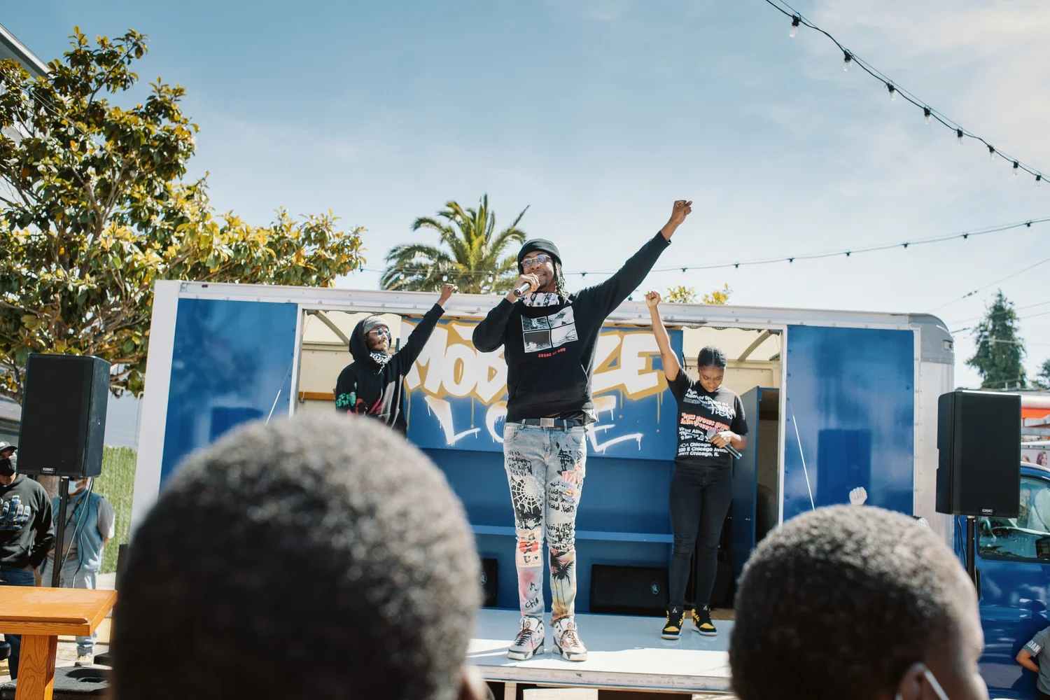 Speaker raising an arm on the outdoor stage.