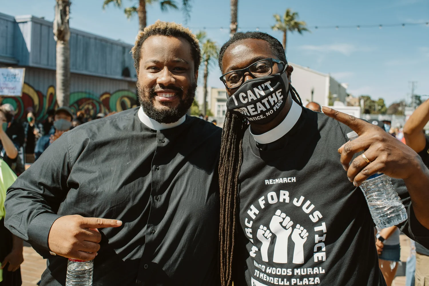 Two participants with clerical collars posing with arms around each other.