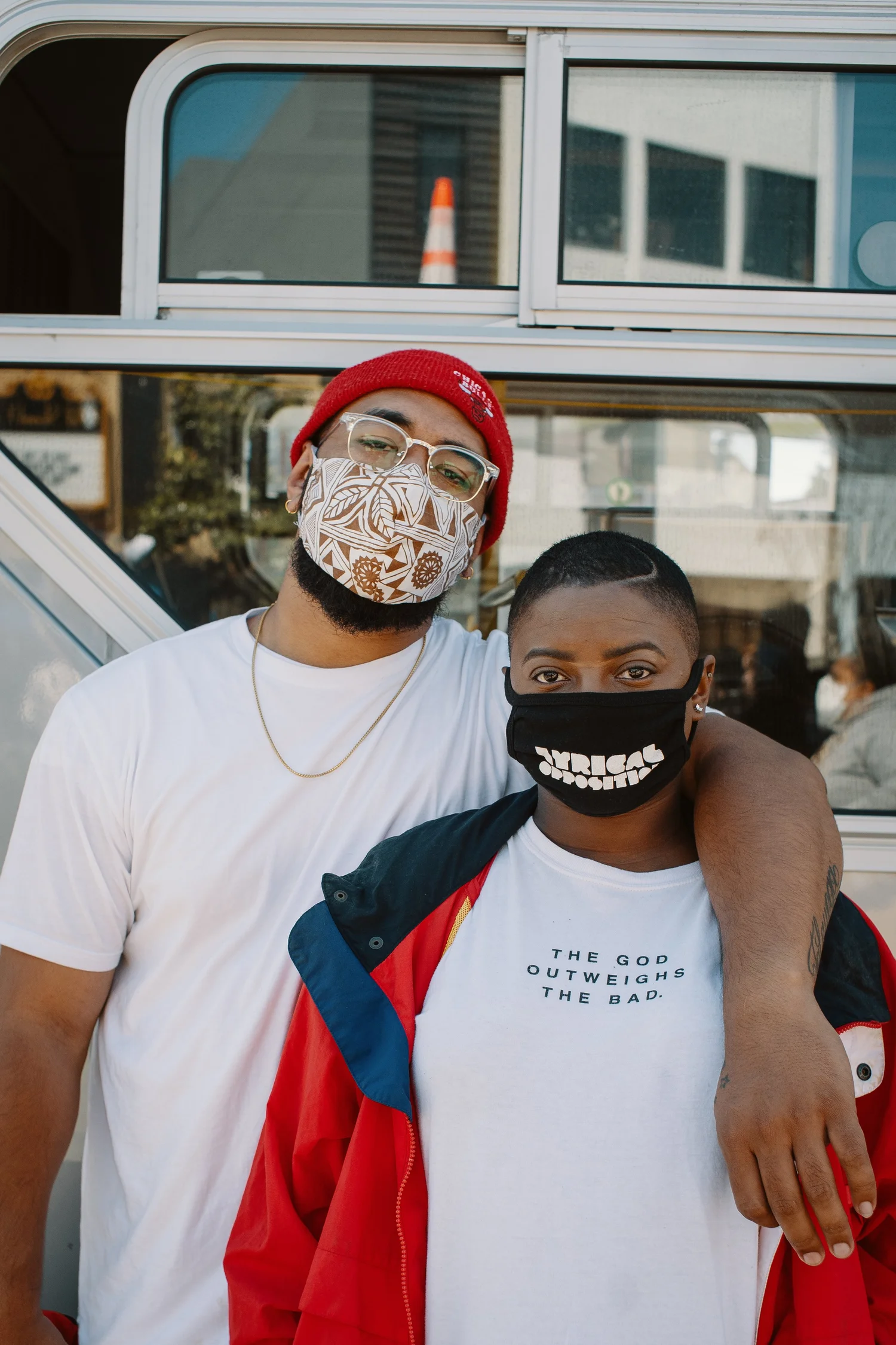 Two masked participants posing with an arm around one another.