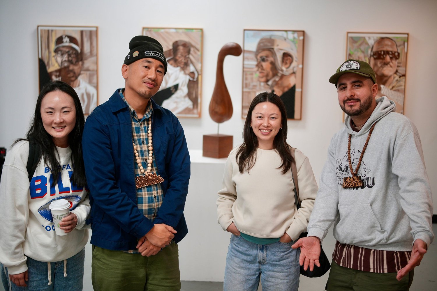 Four guests smile together in the gallery.