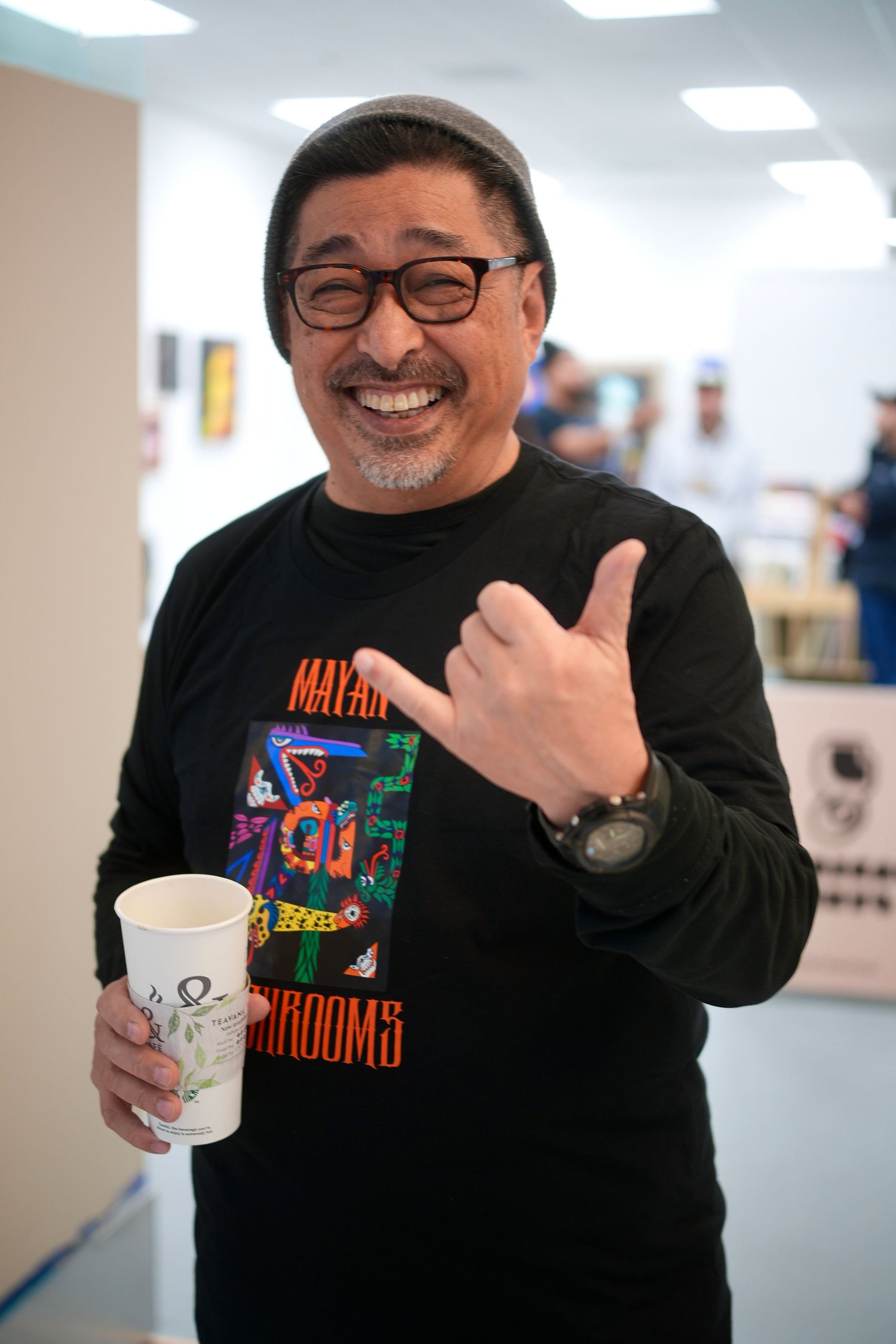 A smiling guest makes a shaka hand gesture.