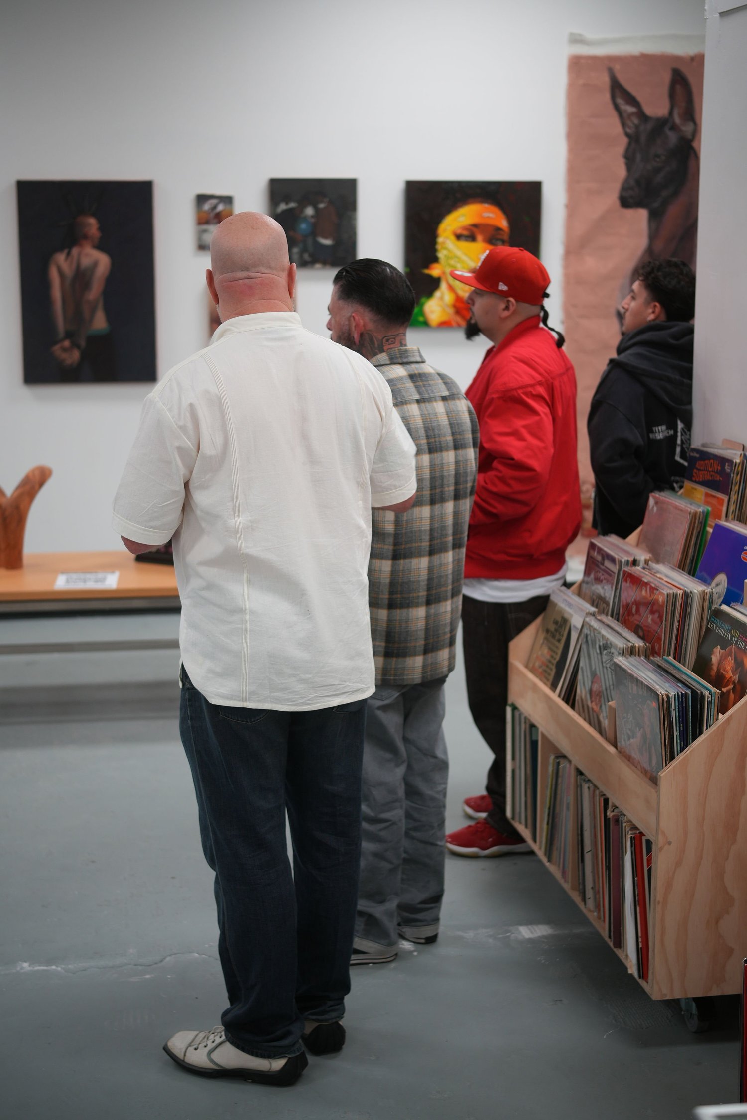 Guests talk beside framed portraits and vinyl records.